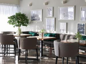 a dining room with tables and chairs and plants at Cactus Hotel in Rhodes Town