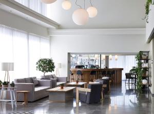 a living room with couches and tables and a bar at Cactus Hotel in Rhodes Town