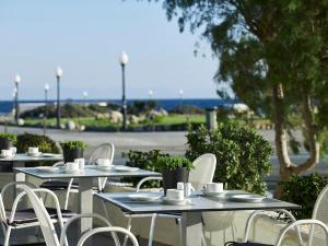 a row of tables and chairs with plants on them at Cactus Hotel in Rhodes Town