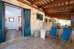 un patio con 2 sillas azules y una mesa en Miramare Residence en Favignana