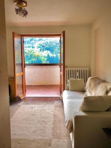 a room with two beds and a large window at La Sorgente - Immersi nella natura in Limone Piemonte