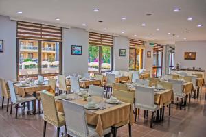 a dining room with tables and chairs and windows at Yaman Life Hotel in Alanya