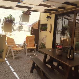 un patio con sillas, una mesa de madera y un banco en vacanze in sardegna, en SantʼAndrea