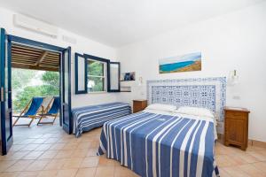 a bedroom with a bed, chair and a window at Miramare Residence in Favignana