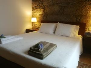 Una cama con una bandeja con una flor azul. en Casas Marias de Portugal - Cerveira en Vila Nova de Cerveira