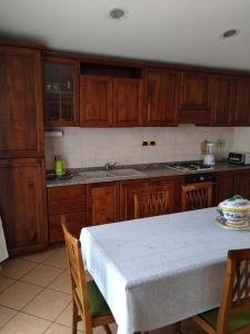 una cocina con armarios de madera y una mesa con mantel. en CASA DI ALFEO en Perugia