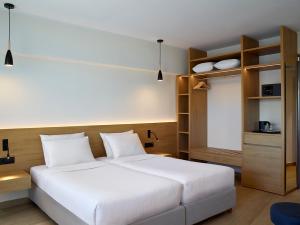 a bedroom with a large white bed and shelves at Cactus Hotel in Rhodes Town