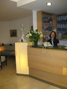 Eine Frau, die an einem Tresen in einem Salon sitzt. in der Unterkunft Dom Hotel in Linz