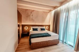 a bedroom with a bed and a large window at PRADA' Home Eco Suites in Bardolino