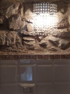 a chandelier hanging from a stone wall in a bathroom at Fra Bosco e Cielo B&B in Mercato Saraceno +29 photos