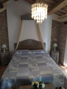 a bedroom with a bed and a chandelier at Fra Bosco e Cielo B&B in Mercato Saraceno
