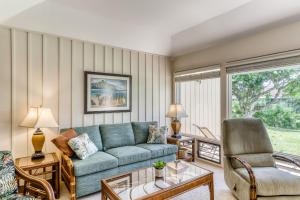 a living room with a couch and a chair at Manualoha 203 in Koloa