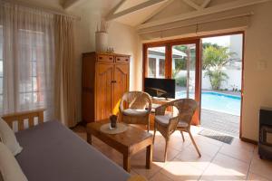 a living room with a couch and a table and chairs at Inn2Wilderness Guesthouse in Wilderness