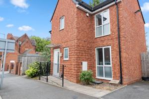 a red brick house with white windows on a street at Royal House Wolverhampton - Perfect for Contractors & Large Groups in Wolverhampton