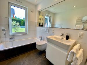 ein Bad mit einem Waschbecken, einem WC und einem Fenster in der Unterkunft Vis-Ahr-Vis Country in Bad Neuenahr-Ahrweiler