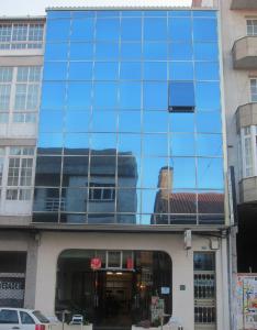 a glass building with a reflection of a building at Hostal Conde Rey in Bandeira