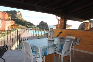 einen Tisch und Stühle auf einem Balkon mit Meerblick in der Unterkunft VILLA TRAMONTI SUL MARE in Nebida