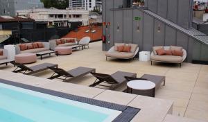 a rooftop patio with chairs and tables and a pool at Zenit Convento San Martin in Donostia-San Sebastián