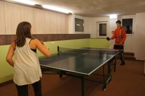 a man and a woman playing ping pong at Hotel Alpenblick in Bad Gastein
