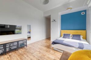 a bedroom with a bed and a tv on a wall at Studio Art - Shopping center and train station 500m - Disneyland Paris 5min in Montévrain
