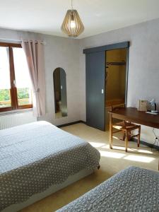 1 dormitorio con 2 camas, mesa y piano en Logis hôtel Les Confins du perche, en Sceaux-sur-Huisne