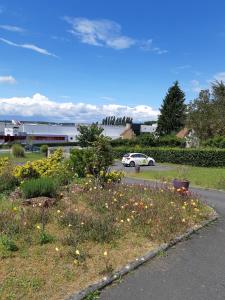 a car is parked in a parking lot with flowers at Logis hôtel Les Confins du perche in Sceaux-sur-Huisne