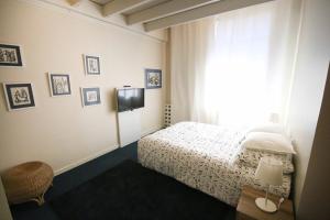 1 dormitorio con 1 cama, TV y ventana en Les petits poissons, en Aviñón