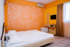 a bedroom with a bed and a tv on a wall at Hotel Meridian in Costinesti