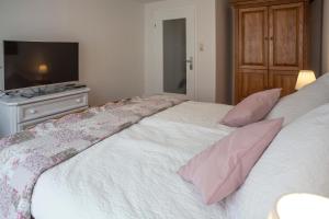 a bedroom with two beds with pink pillows and a television at Ferienwohnung Alt Einbeck in Einbeck