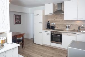 a kitchen with white cabinets and a table and a sink at Ferienwohnung Alt Einbeck in Einbeck