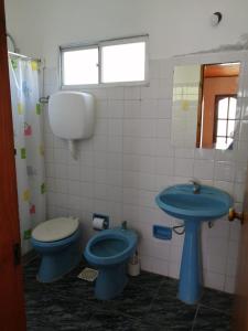 a bathroom with a blue toilet and a sink at POSADA SANTA CECILIA in Termas del Daymán