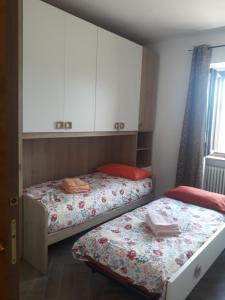 a bedroom with two beds and a cabinet and windows at Piccolo Paradiso in pieno centro Pescocostanzo in Pescocostanzo