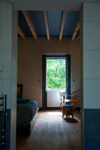 1 dormitorio con cama y ventana grande en l'Ancre Vive, en Charentay