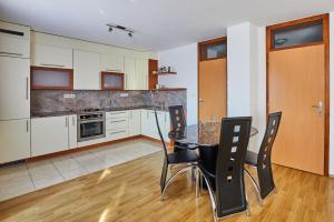 Sutjeska في Modriča: مطبخ مع طاولة وكراسي في غرفة