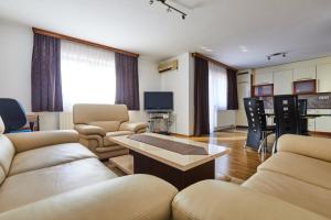 Sutjeska في Modriča: غرفة معيشة بها كنب وطاولة وتلفزيون