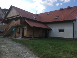 una casa grande con techo rojo en un patio en Dom Młodzieżowy w Polanie, en Serednie Małe