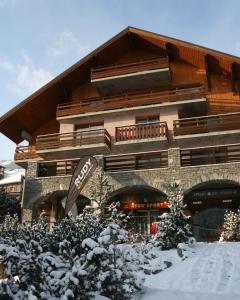 a large building with snow on the ground in front of it at Les Balcons de Vaujany in Vaujany