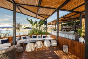 a bar with white tables and chairs and a view of the ocean at Kaya Palazzo Resort & Residences Le Chic Bodrum in Bodrum City
