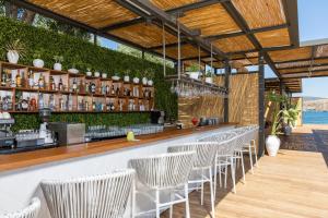 a bar with a row of chairs in a restaurant at Kaya Palazzo Resort & Residences Le Chic Bodrum in Bodrum City