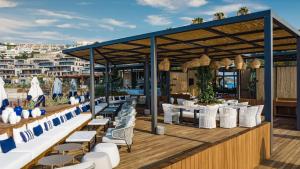 a restaurant with white tables and chairs on a deck at Kaya Palazzo Resort & Residences Le Chic Bodrum in Bodrum City