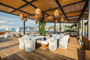 a patio with white chairs and tables and a view of the ocean at Kaya Palazzo Resort & Residences Le Chic Bodrum in Bodrum City