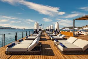 a row of chaise lounges on a pier with the ocean at Kaya Palazzo Resort & Residences Le Chic Bodrum in Bodrum City