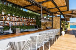 a bar with a row of chairs in a restaurant at Kaya Palazzo Resort & Residences Le Chic Bodrum in Bodrum City