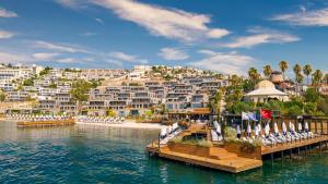 a view of a resort on the water with chairs at Kaya Palazzo Resort & Residences Le Chic Bodrum in Bodrum City