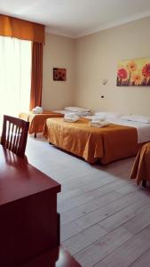 pokój hotelowy z dwoma łóżkami z pomarańczowymi prześcieradłami w obiekcie Hotel Everest w Rzymie