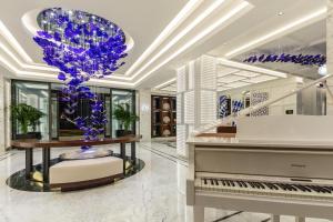 a room with a piano and a vase with purple flowers at Kaya Palazzo Resort & Residences Le Chic Bodrum in Bodrum City
