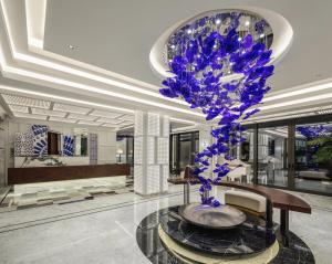 a lobby with a large blue flower in a vase at Kaya Palazzo Resort & Residences Le Chic Bodrum in Bodrum City