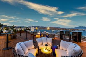 a deck with chairs and tables and a view of the water at Kaya Palazzo Resort & Residences Le Chic Bodrum in Bodrum City