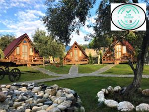 a picture of a log cabin with a pile of rocks at Kazdaglari Ida Natura Bungalov Hotel in Akcay