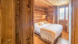 シャテルにあるDormeur - Chalet - BO Immobilier- Châtel-,remises sur les forfaits de skis Châtel ou Portes du soleilの木造キャビン内のベッド1台が備わるベッドルーム1室を利用します。